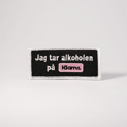 Svart tygmärke med texten "Jag tar alkoholen på Klarna"