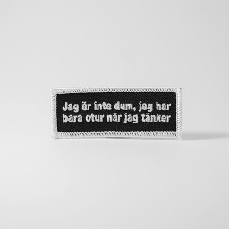 Svart tygmärke med texten 