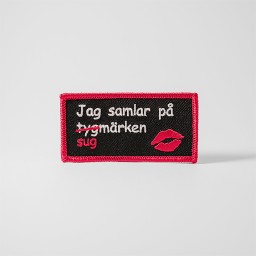 Svart tygmärke med texten 