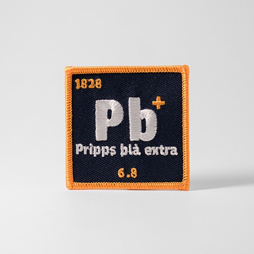 Blått tygmärke med texten "Pb+"